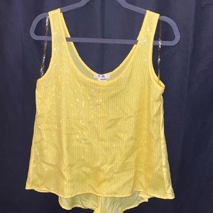 Sleeveless yellow sequin top, with slit in lower back.